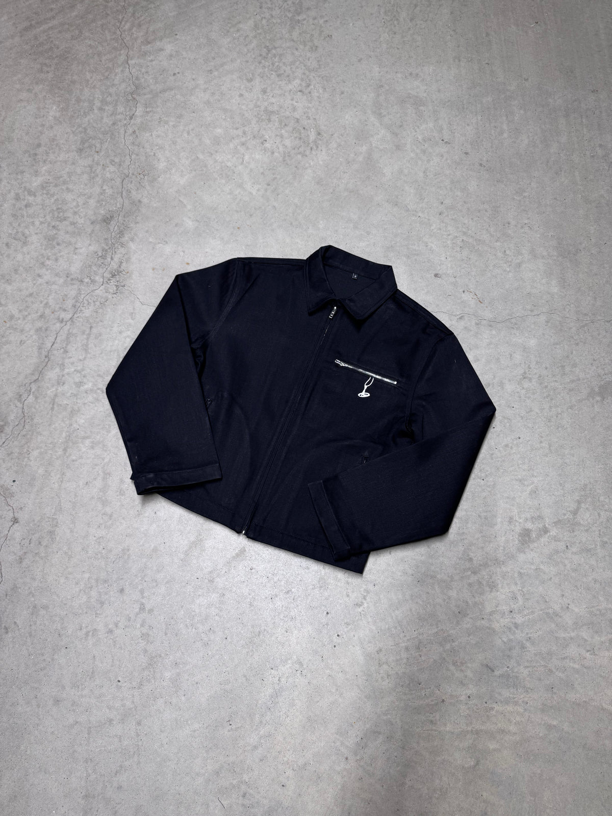 Veste noire signature DIVICE – posée à plat, vue de face