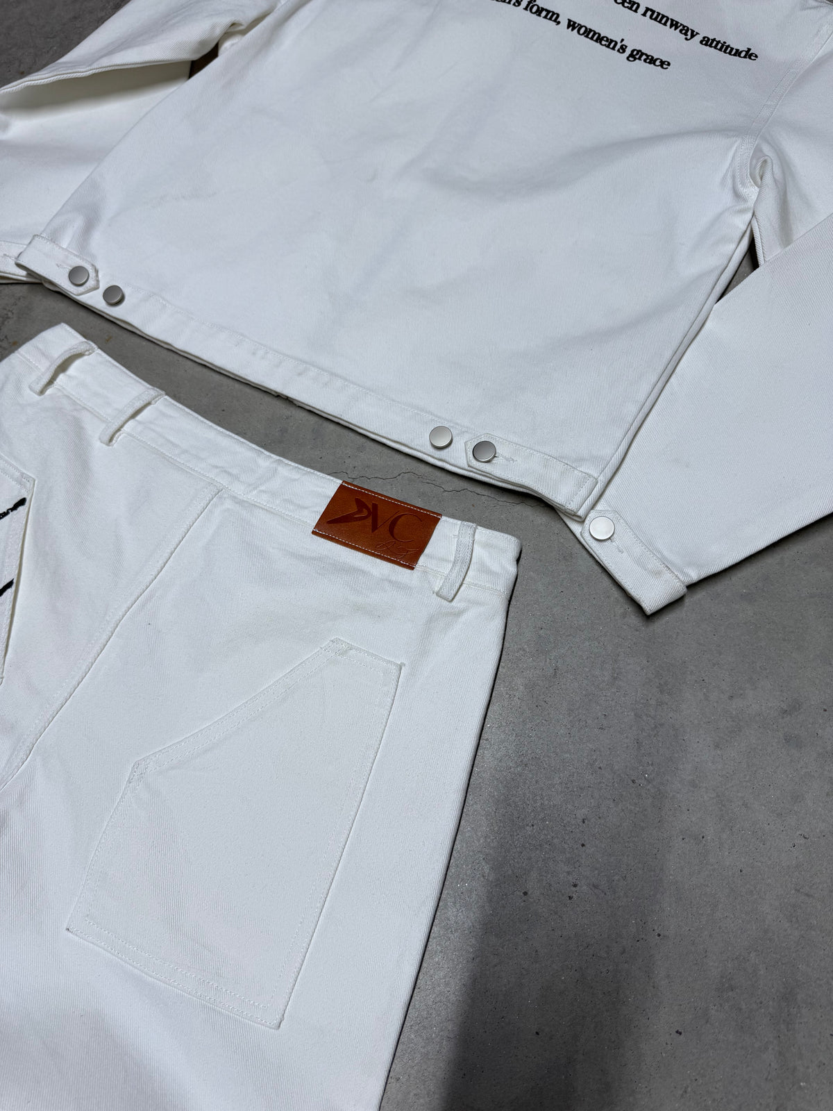 Veste blanche signature DIVICE – détail des boutons pression, avec l'étiquette du jean